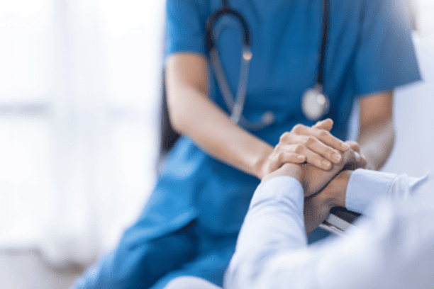 Caregivers providing support to elderly person.